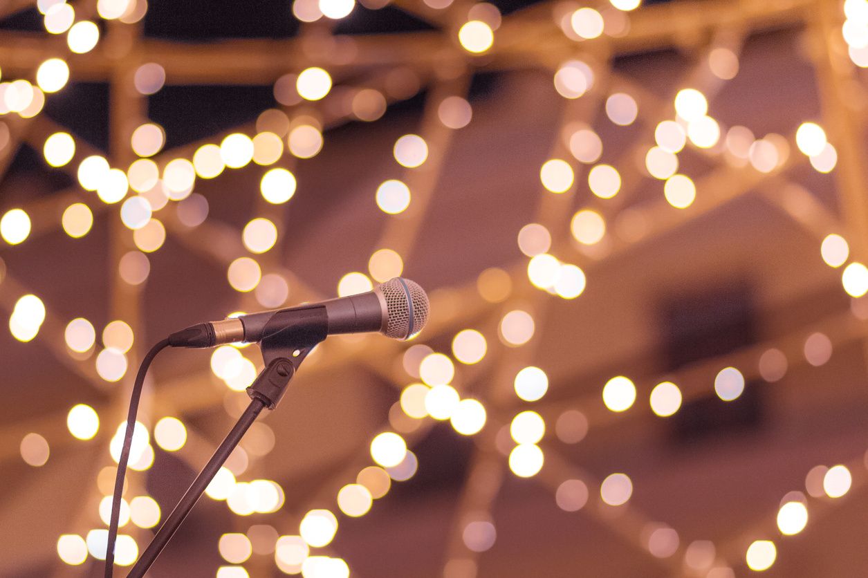 Microphone at a wedding with lighting strun throughout the reception getting ready for wedding speeches